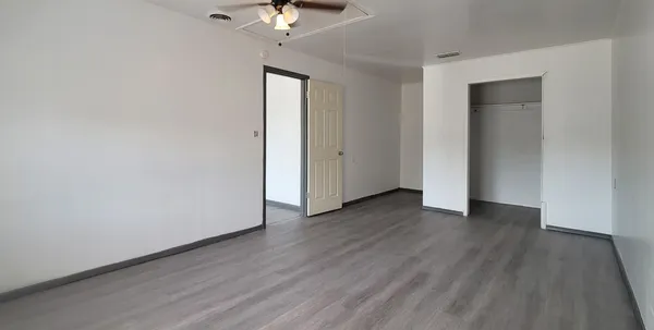 a view of an empty room with wooden floor
