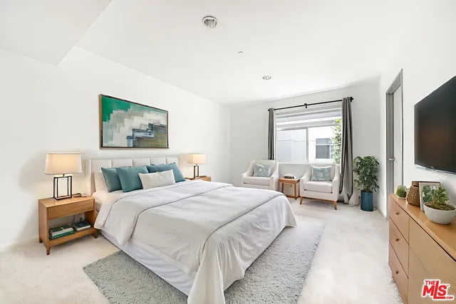 a bedroom with a bed and a flat screen tv