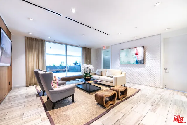 a living room with furniture wooden floor and a large window