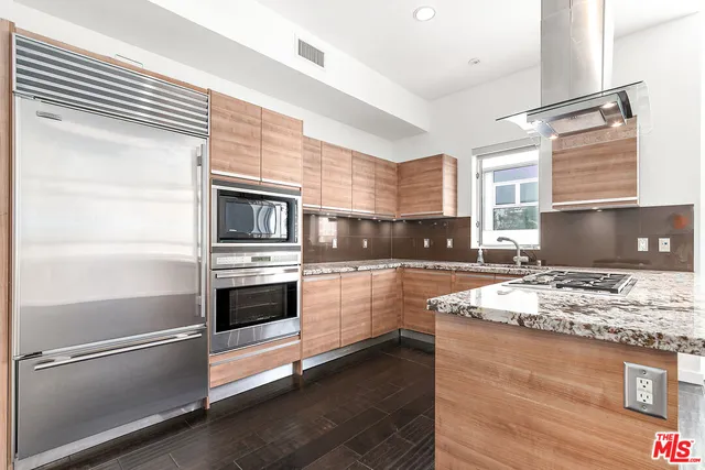 a kitchen with stainless steel appliances and granite countertop refrigerator