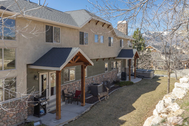 5168 Fairview Loop, Unit C604 Eden, UT 84310 - Photo 37 of 53 View of front of property with a hot tub, a shingled roof, a patio area, and a chimney