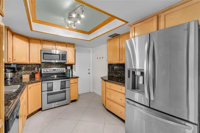 a kitchen with stainless steel appliances granite countertop a refrigerator and a stove top oven