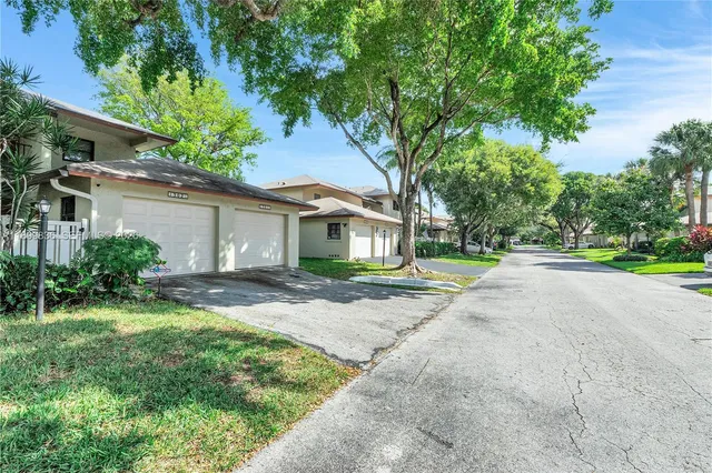 a view of a house with a yard and large tree