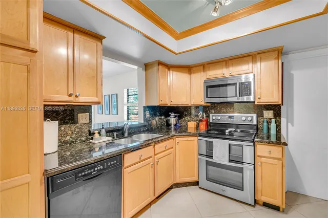 a kitchen with stainless steel appliances granite countertop a stove a sink and a microwave