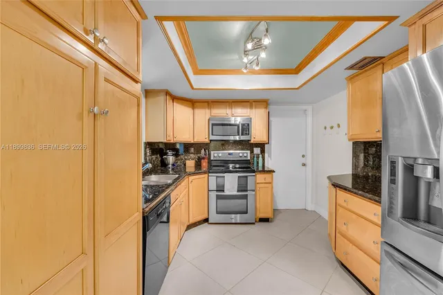 a kitchen with stainless steel appliances granite countertop a refrigerator and a stove top oven