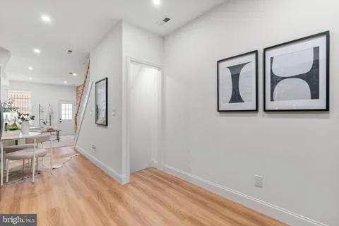 a view of a hallway with wooden floor and chair