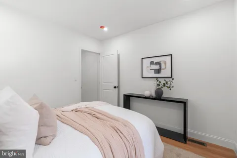 a bedroom with a bed and painting on the wall