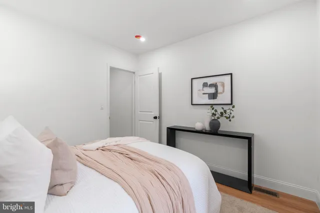 a bedroom with a bed and painting on the wall