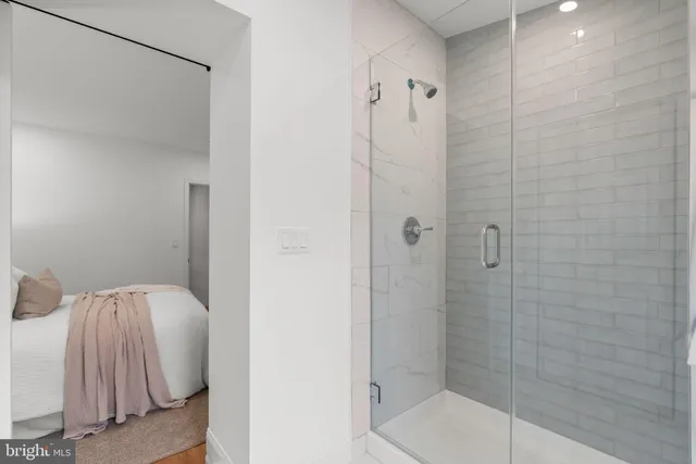 a bedroom with a bed and a large mirror next to a window