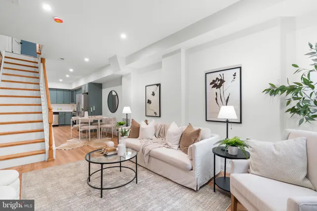 a living room with furniture potted plant and white walls