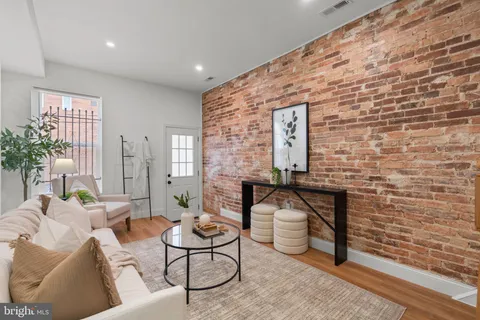 a living room with furniture a fireplace and a potted plant