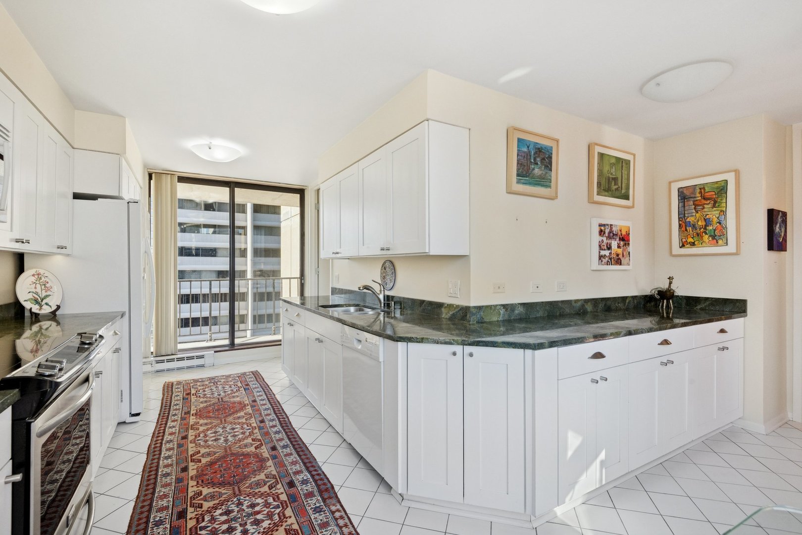 1410 North State Parkway, Unit 18B Chicago, IL 60610 - Photo 13 of 31 a kitchen with granite countertop a sink and cabinets