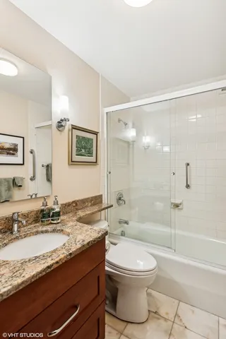 a bathroom with a granite countertop toilet sink and shower