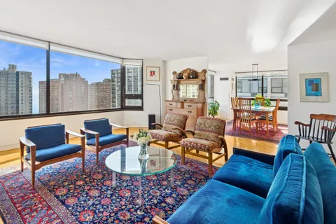 a living room with furniture and a floor to ceiling window