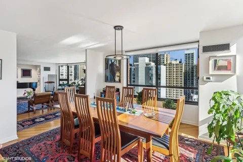 a dining room with furniture floor to ceiling window and potted plants