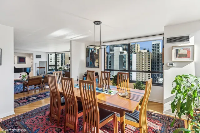 a dining room with furniture floor to ceiling window and potted plants