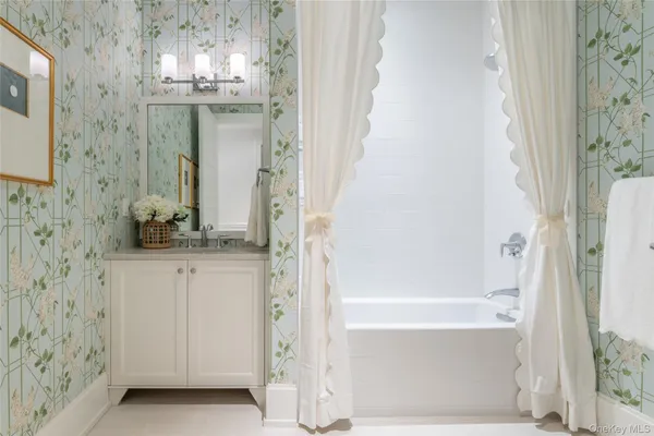 a bathroom with a granite countertop shower a sink and a mirror