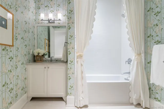 a bathroom with a granite countertop shower a sink and a mirror