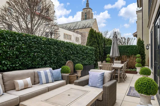 a view of a patio with couches potted plants and a palm tree