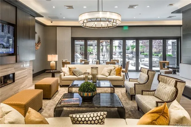 a living room with furniture chandelier and a large window
