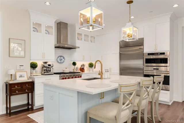 a kitchen with stainless steel appliances a stove a table and chairs in it