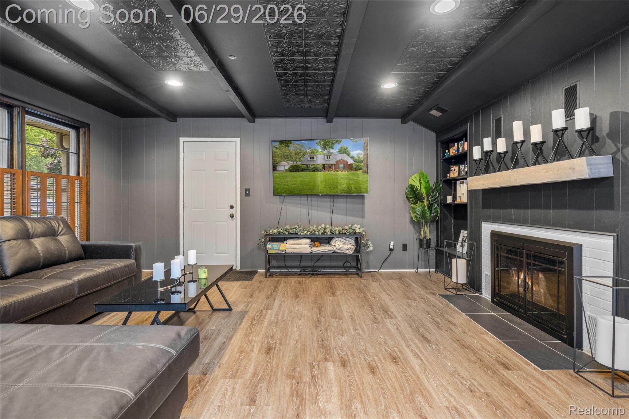 6085 Worlington Road Bloomfield Hills, MI 48301 - Photo 23 of 75 Spacious 2nd Living Room featuring wood-finish flooring, a contemporary fireplace with a light-colored mantel, built-in shelving, gray vertical paneling, and a dark ceiling with exposed beams and recessed lighting