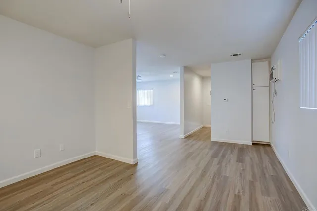 a view of a room with wooden floor and white walls