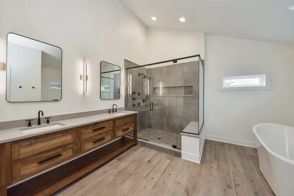 a bathroom with a sink a toilet a mirror and shower