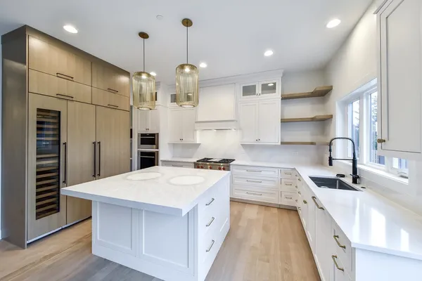 a large kitchen with kitchen island a stove a sink a center island and wooden floor