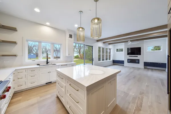 a large kitchen with kitchen island a sink stainless steel appliances and cabinets