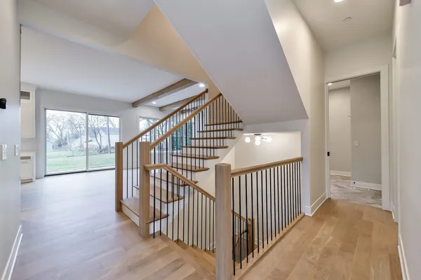 a view of a hallway with wooden floor and windows