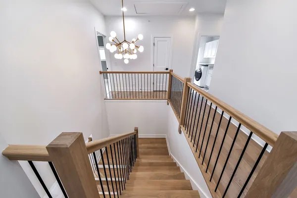 a view of a hallway with wooden floor and chandelier