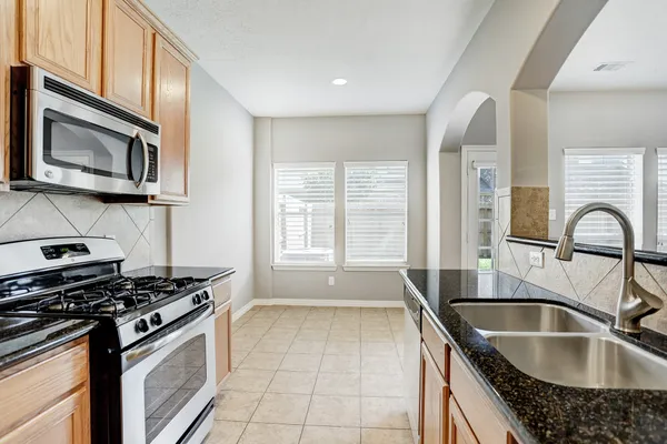 a kitchen with a sink stove top oven and microwave