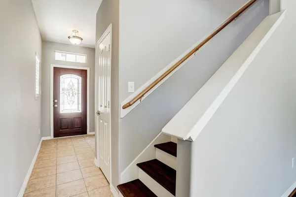 a view of a hallway with wooden floor and staircase