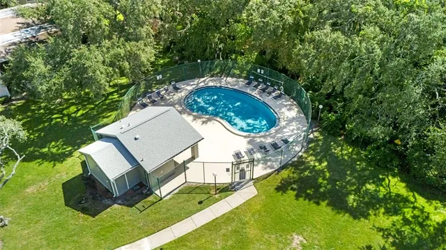 an aerial view of a house with a yard and trees
