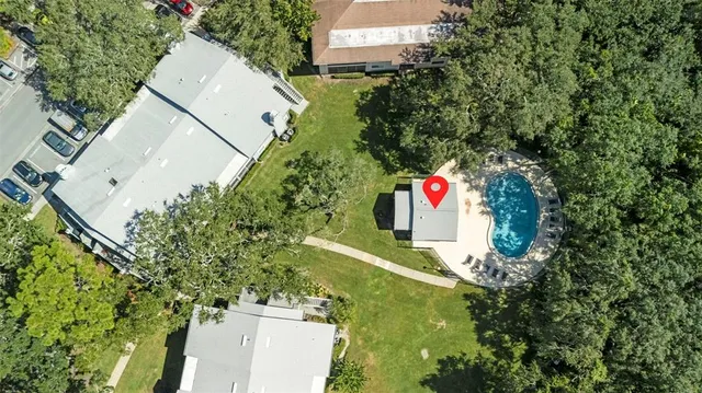 an aerial view of residential house with outdoor space and trees all around