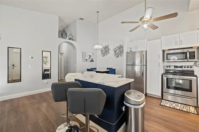 a kitchen with stainless steel appliances a dining table chairs and chandelier
