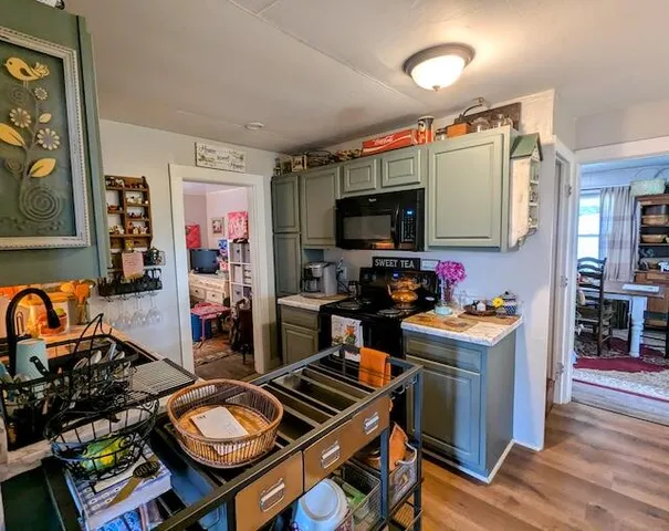 a kitchen with stainless steel appliances a stove a sink dishwasher and cabinets with wooden floor