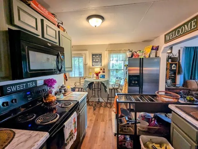 a kitchen with stainless steel appliances kitchen island granite countertop a stove and a microwave