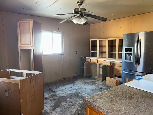 a kitchen with stainless steel appliances granite countertop a refrigerator a stove and a sink