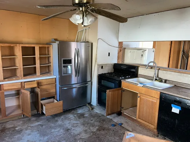 a kitchen with stainless steel appliances kitchen island granite countertop a stove a sink and a refrigerator