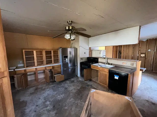 a kitchen with stainless steel appliances kitchen island granite countertop a stove refrigerator and cabinets
