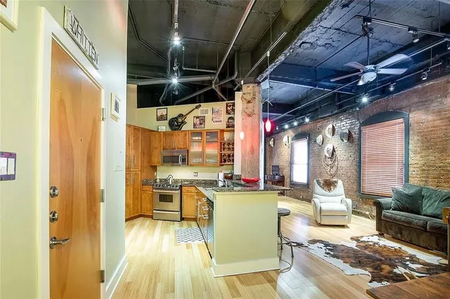 a living room with stainless steel appliances furniture stove and a kitchen view
