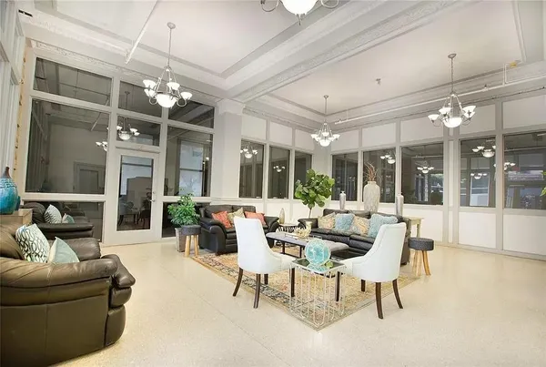a living room with furniture a chandelier and a large window