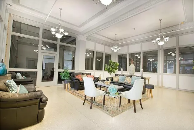 a living room with furniture a chandelier and a large window