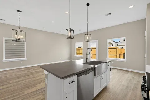 a kitchen with granite countertop a sink a center island and wooden floor