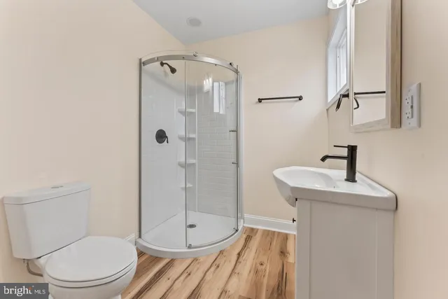 a bathroom with a sink a toilet and shower