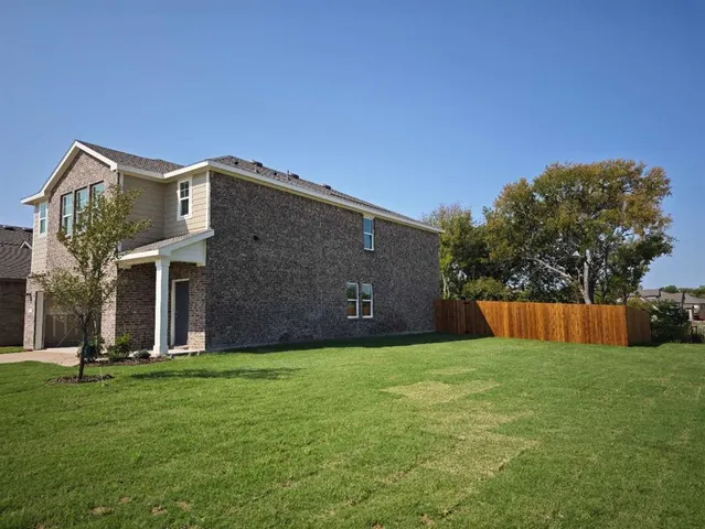 a view of a house with backyard and trees