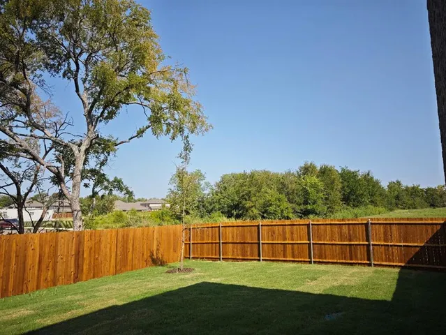 a view of green field with a tree in the background