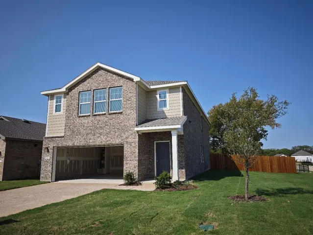 a front view of a house with a garden and yard